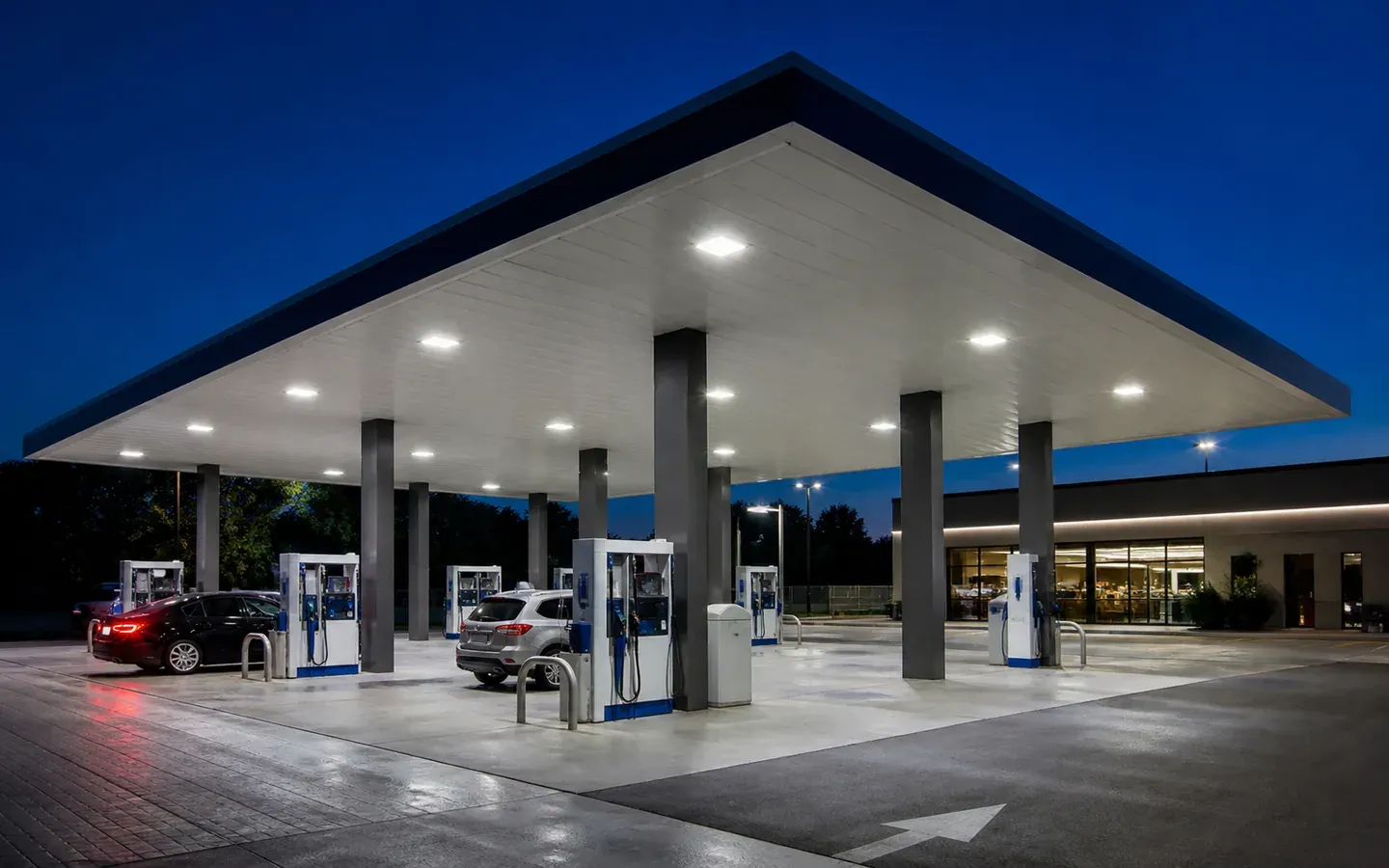Recessed LED canopy lights illuminating a fuel station forecourt at night